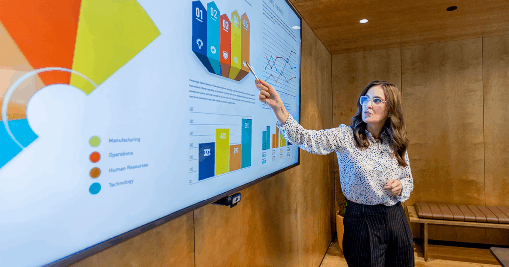 Woman giving a presentation using a digital screen with charts